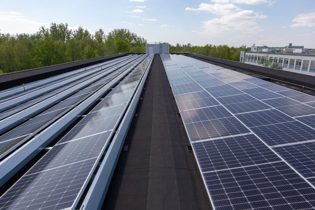 Solarmodule auf Flachdach bei Tageslicht.